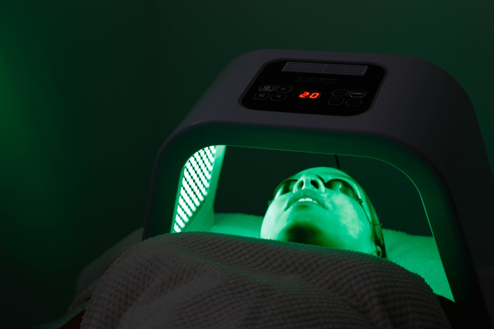 Mascarilla LED de luz verde durante un tratamiento facial